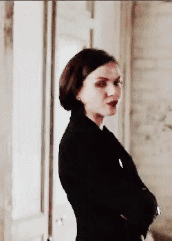 a woman is standing with her arms crossed in a room