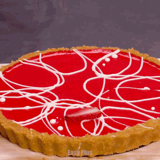a person is adding a strawberry to a pie that says easy plus on the bottom
