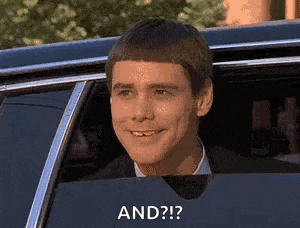 a man is smiling while sitting in a car and looking out the window .