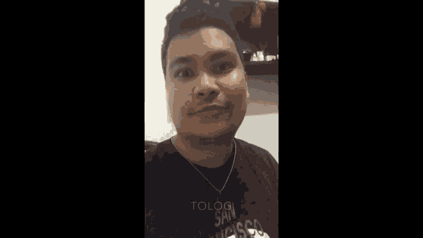 a man with a beard wearing a black shirt and a necklace with the word tolog on it
