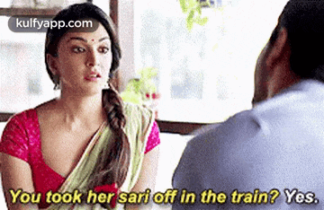 a woman in a sari is talking to a man .