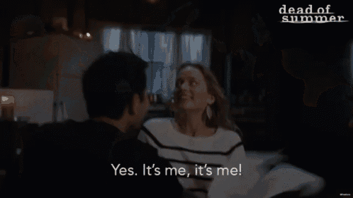 a man and a woman are sitting at a table and the woman is saying " yes it 's me it 's me "