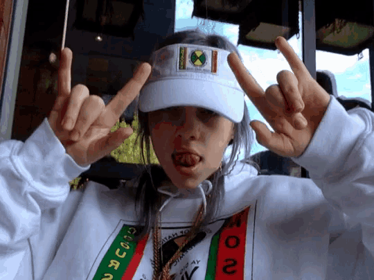 a girl wearing a white visor and a sweatshirt that says ' no ' on it