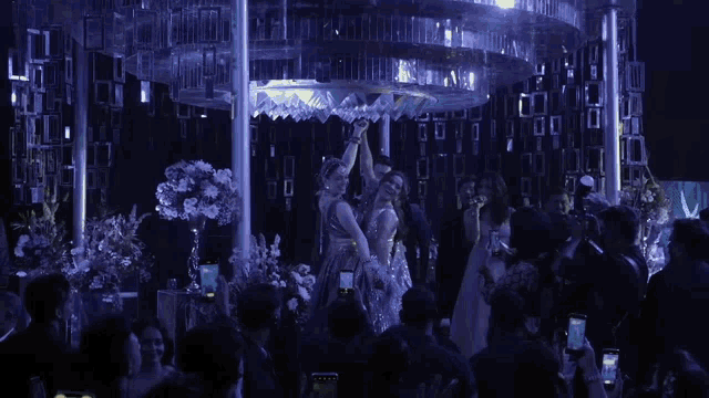 a group of people are taking pictures of a woman on a stage at a party