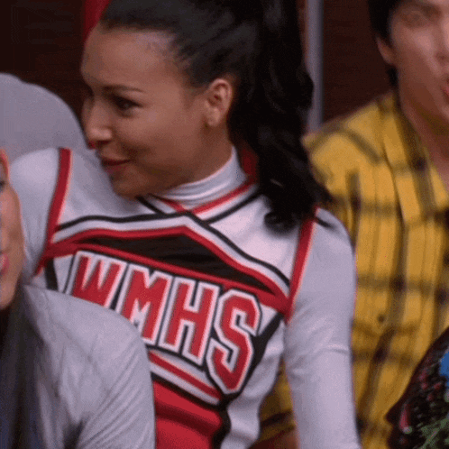 a cheerleader wearing a wmhs uniform is sitting in a crowd