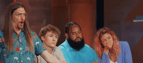 a group of people are standing next to each other on a stage and laughing .