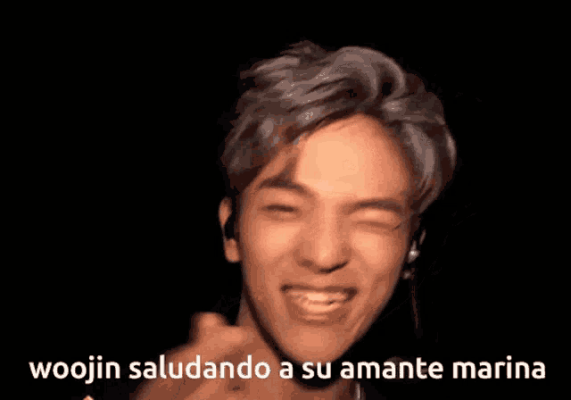 a picture of a young man with the words woojin saludando a su amante marina below him