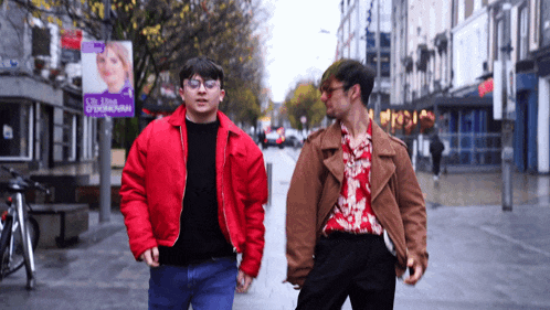 two men are walking down a street in front of a sign that says ' o'donovan '