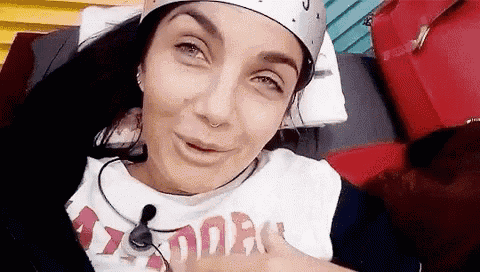 a woman wearing a crown and a t-shirt is laying on a couch .