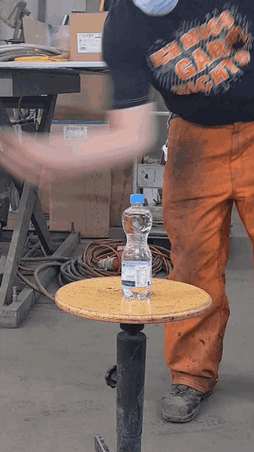 a man wearing a shirt that says harley davidson is standing next to a bottle of water