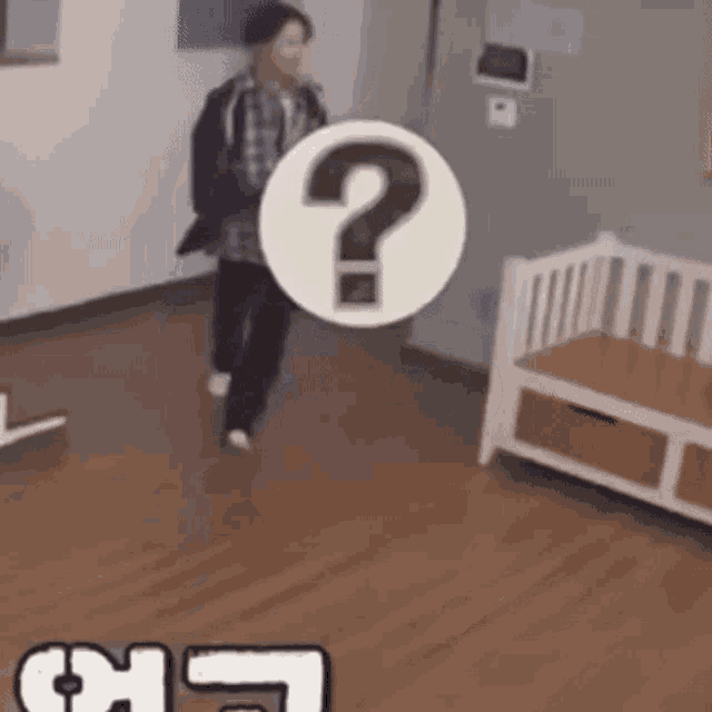 a man is walking in a room with a question mark in the middle of the room .