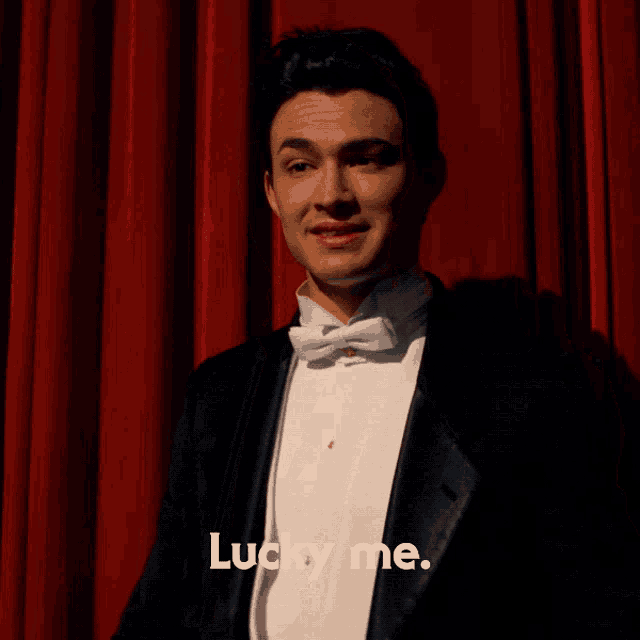 a man in a tuxedo says " lucky me "