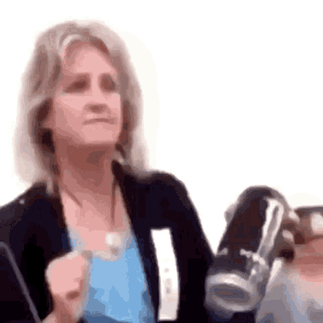 a woman in a blue shirt is holding a can of soda in her hand .