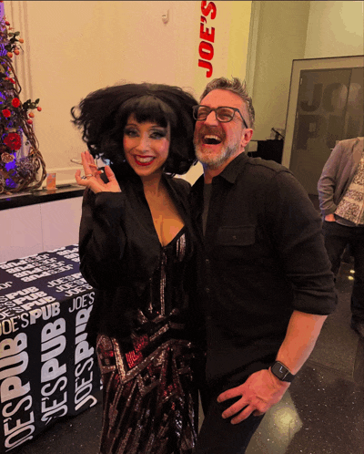 a man and a woman are posing for a photo in front of a table that says joe 's pub