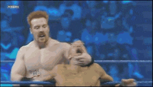 two men are fighting in a wrestling ring and one of them has a w on his belt
