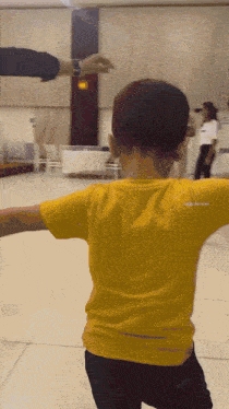 a young boy wearing a yellow shirt with the word apple on it