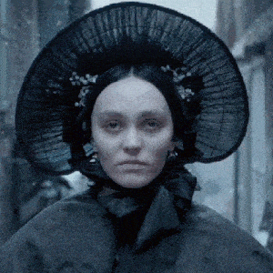 a woman wearing a black hat and a black cape