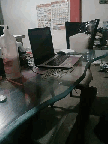 a bottle of milk sits on a table next to a computer