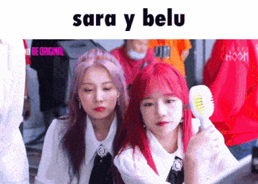 two girls with red hair are standing next to each other under a sign that says sara y melu