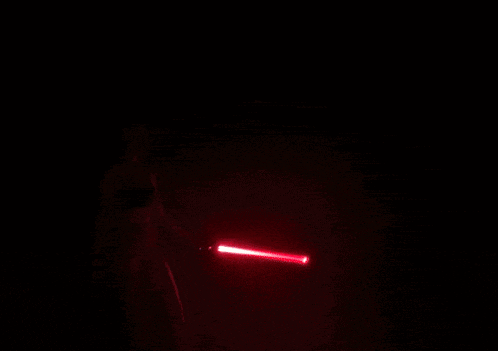 a person is holding a flashlight in the dark