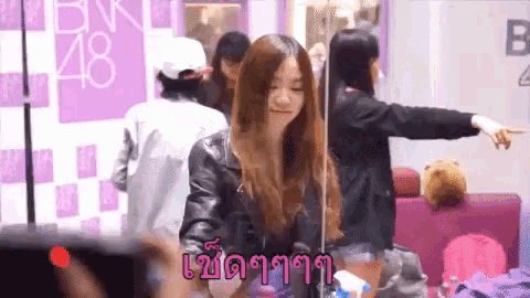 a girl in front of a bnk48 sign
