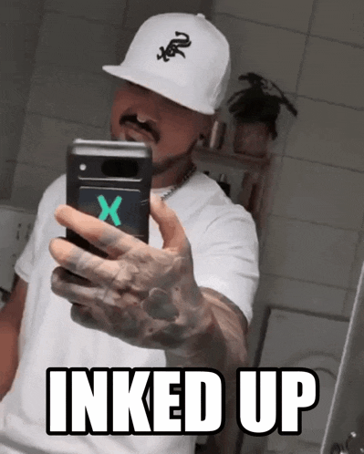 a man taking a picture of himself with the words inked up below him