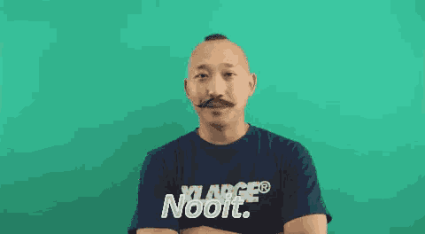 a man with a mustache is wearing a blue shirt that says xlarge nooit