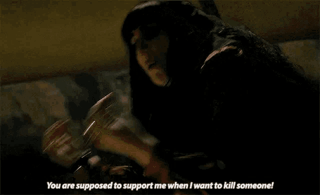 a woman in a dark room is screaming and saying `` you are supposed to support me when i want to kill someone ''