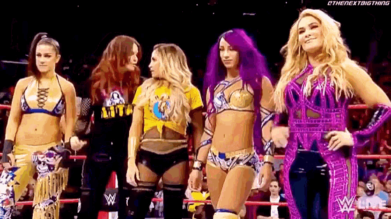 a group of women are standing in a wrestling ring .