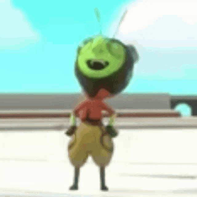 a cartoon character with a green head and yellow shorts is standing on the ground .