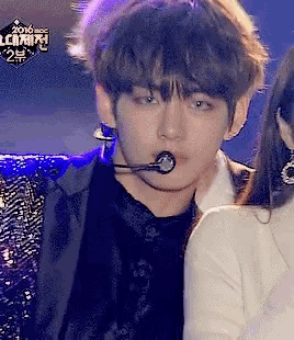 a man with a microphone in his mouth stands next to a woman .