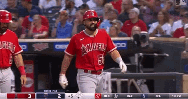 a baseball player for the angels is walking towards home plate .