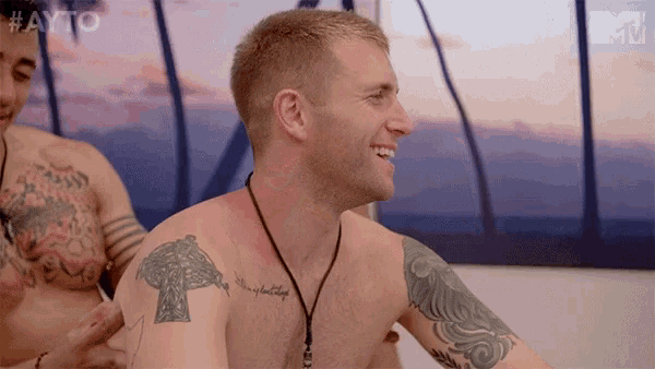 a shirtless man has a tattoo on his shoulder that says " king of all kings "