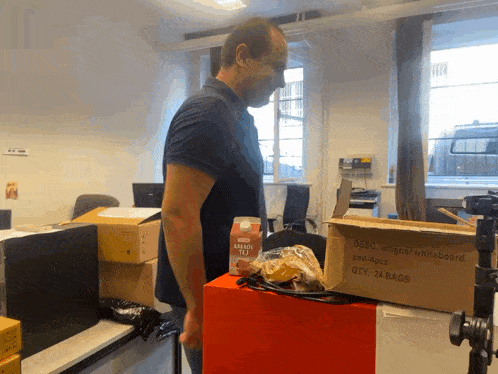 a man standing next to a box that says desc magnet whiteboard on it