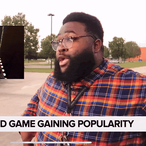 a man wearing glasses and a lanyard with the words d game gaining popularity