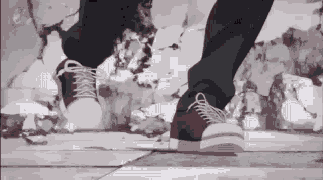 a person wearing a pair of white sneakers is walking on a tiled floor .