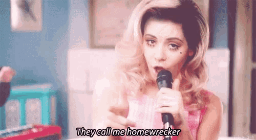 a woman is singing into a microphone with the words `` they call me homewrecker '' .