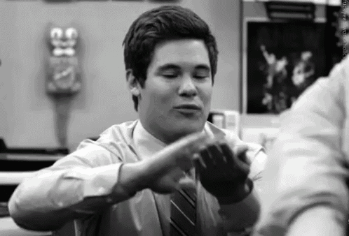a black and white photo of a man in a suit and tie making a funny face .