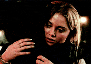 a woman with a ring on her finger holds another woman 's face