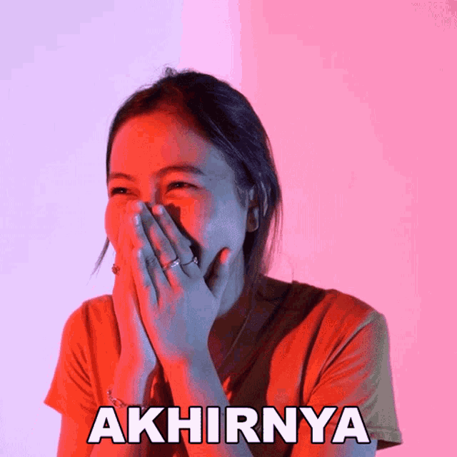a woman is covering her mouth with her hands and the word akhirnya is on the bottom right