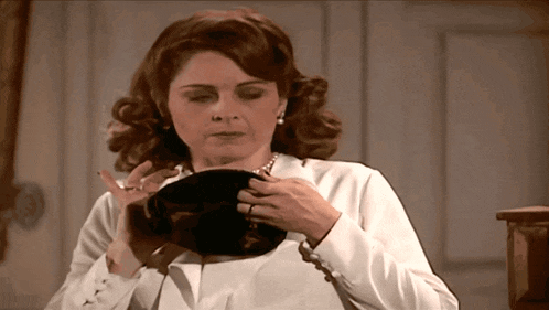 a woman looking at herself in a mirror with a ring on her finger