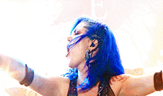 a woman with blue hair and a tattoo on her arm is dancing