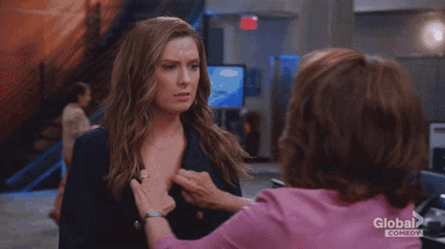 a woman in a red bra is being hugged by another woman in a pink shirt from global comedy