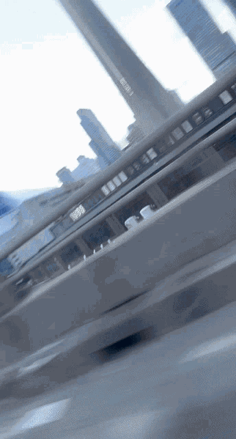 a blurry picture of a bridge with a few buildings in the background including one that says ' sydney ' on it