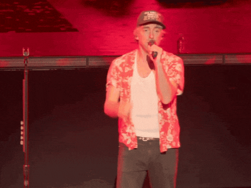 a man singing into a microphone wearing a hat that says ' u.s. navy ' on it