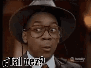 a young man wearing glasses and a hat is making a funny face and says `` tal vez '' .