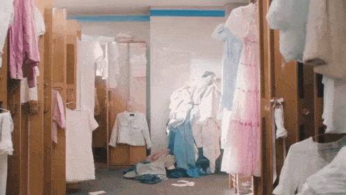 a locker room filled with lots of clothes hanging on the doors .