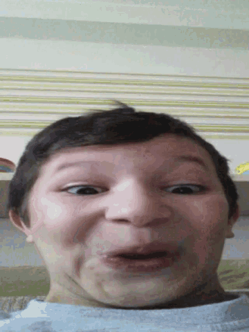 a young boy making a funny face with his mouth wide open