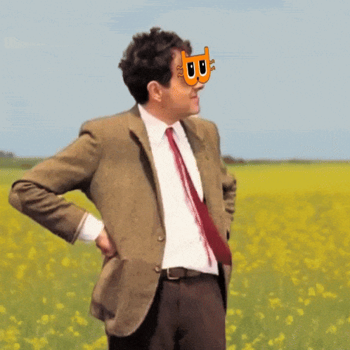 a man in a suit and tie stands in a field of flowers