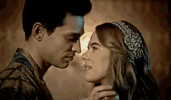 a man and a woman are kissing in front of a light .